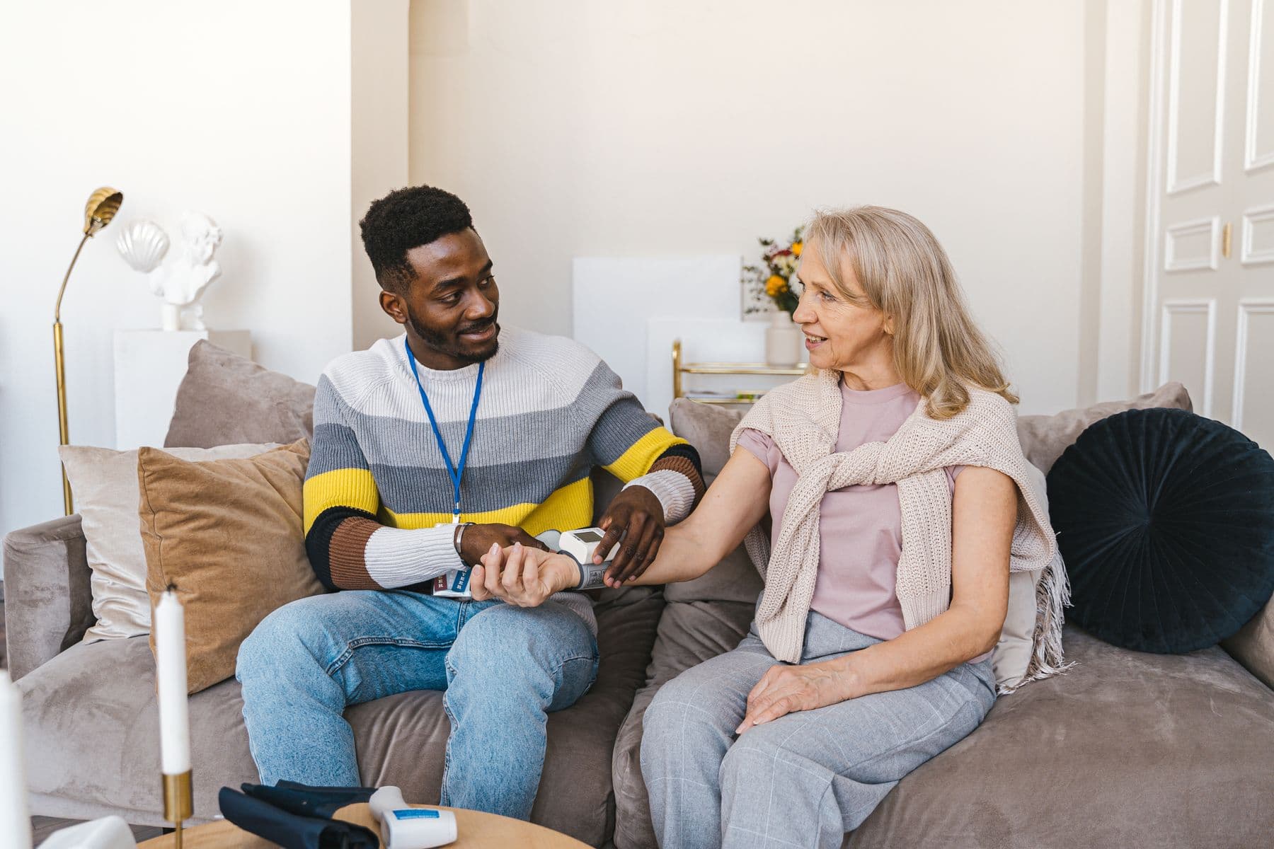 A carer checking blood pressure for an older person at home
