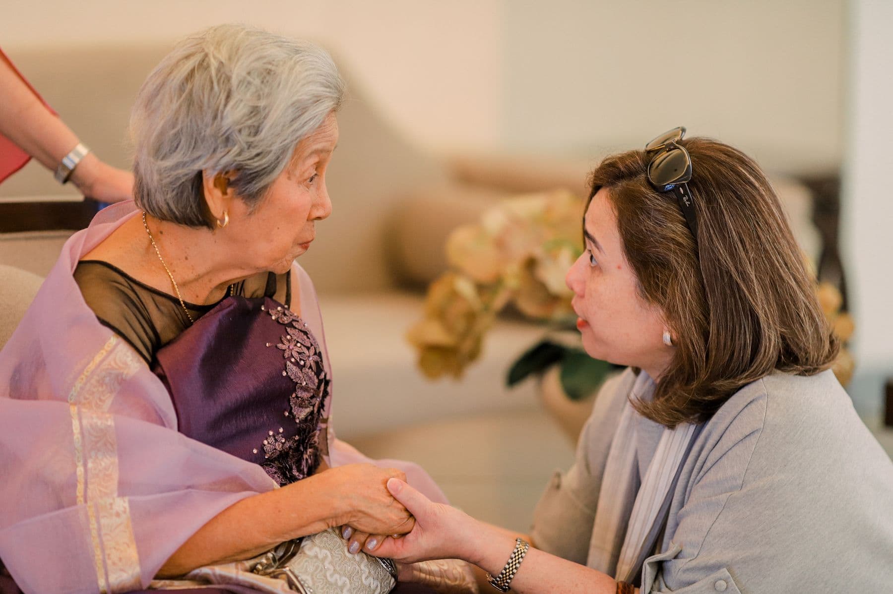 An older woman and her adult daughter sharing a quiet moment at home